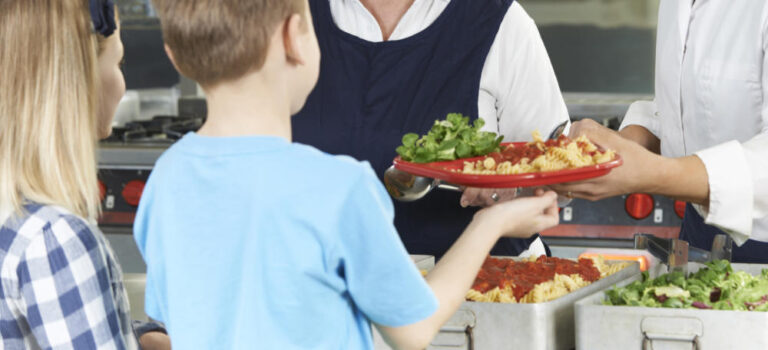 Pupils In School Cafeteria Being Served Lunch